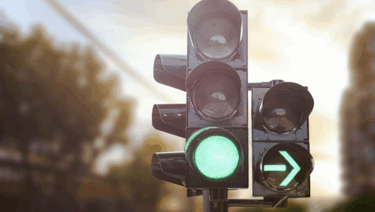 Photo of a traffic light and an advanced green arrow to illustrate the right of way in driving | Daniel Stark Law